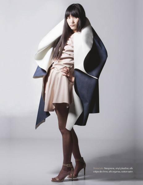 A woman poses in "Emerging Fashion Designers 5" by Schiffer Publishing, Ltd., wearing bold, sculptural looks that showcase new designer talent, styled against a plain studio background.
