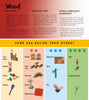 Wood" by Schiffer Publishing, Ltd. is an illustrated children's guide featuring wood crafts like a city block, rabbit, fish, rattle, puzzle, race cars, dinosaur, marble run, billboard, bird, plane, skiers, and trapeze artist—each with a difficulty rating.