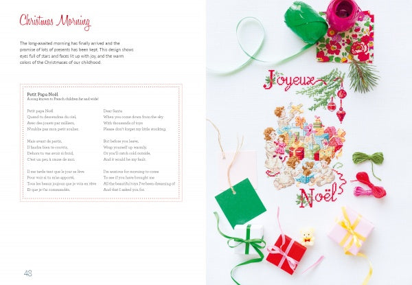 The Magic of Christmas to Cross Stitch by Schiffer Publishing, Ltd. is open to a festive pattern with Joyeux Noël, colorful threads, small gifts, and craft supplies on white. The left page is titled Christmas Morning—ideal for holiday cross-stitch ideas.