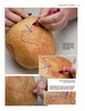 A person uses Apples to Apples by Schiffer Publishing, Ltd. to learn beginner techniques, drawing colorful hearts and words on gourds—perfect close-ups for creative gourd art and decoration projects.