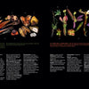 In the Atlas of Flowering Plants by Schiffer Publishing, Ltd., a two-page spread displays vibrant tropical plant parts—flowers, fruits, seeds—artfully arranged on black with captions in white and green fonts describing their anatomy.