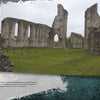 Tall stone arches and walls of Glastonbury Abbey rise from green grass under a moody, overcast sky—an ideal scene for ghost stories explored in "Haunted Britain" from Schiffer Publishing, Ltd.