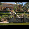Mediterranean Architecture by Schiffer Publishing, Ltd. features a grand villa with terraced gardens, stone steps, manicured bushes, urn planters, a water fountain, and a reflective pond at the entrance.