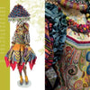 A mannequin in a vibrant, handcrafted-style outfit with patterns, beads, and a lampshade hat echoes the intricate details and layered textures of "Celebrating MacKenzie-Childs" by Schiffer Publishing, Ltd.