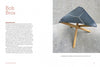 A magazine spread showcases "On the Edge of Your Seat" by Schiffer Publishing, Ltd.: text about designer Bob Brox's influence on American furniture on the left, and a photo of a black triangular stool with wooden legs on a gray stone floor on the right.