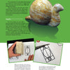 A page from "Introduction to Soapstone Sculpting" by Schiffer Publishing, Ltd. displays a stone snail sculpture and step-by-step illustrated instructions for drawing and carving a snail onto a rectangular piece using soapstone techniques.
