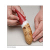 A hand displays a Santa holiday gourd ornament featured in "Making More Gourd Ornaments" by Schiffer Publishing, Ltd.—a festive piece with a red hat, glasses, and beard to enhance your unique holiday décor.