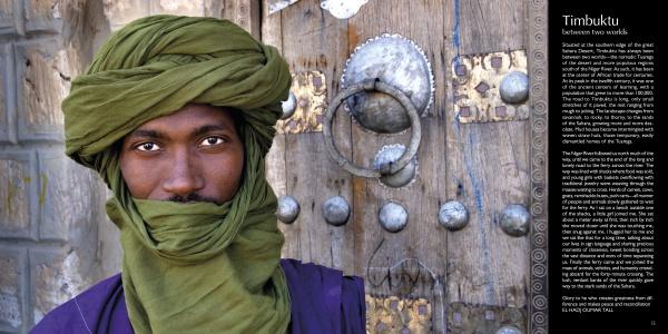 A man in a green turban and robe stands before an ornate wooden door of West African design; on the right, a panel features text about Timbuktu. From "Villages of West Africa" by Schiffer Publishing, Ltd.