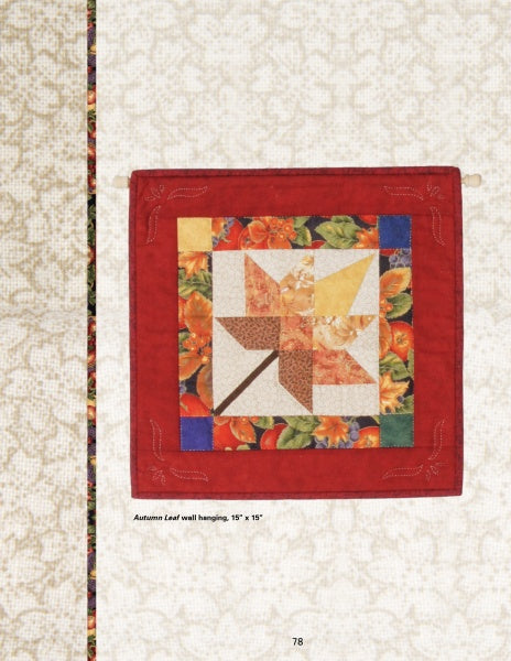 A quilted wall hanging from "Quilts of Chestnut Ridge" by Schiffer Publishing, Ltd. features an autumn leaf pattern in warm tones with a floral border and red edge, displayed on a light background. Text: Autumn Leaf wall hanging, 15 x 15.