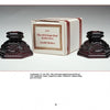 Two ornate, dark red Avon's 1876 Cape Cod Collection candle holders by Schiffer Publishing, Ltd. are displayed with their box, featuring intricate vintage designs—an excellent addition for collectors of American glassware.