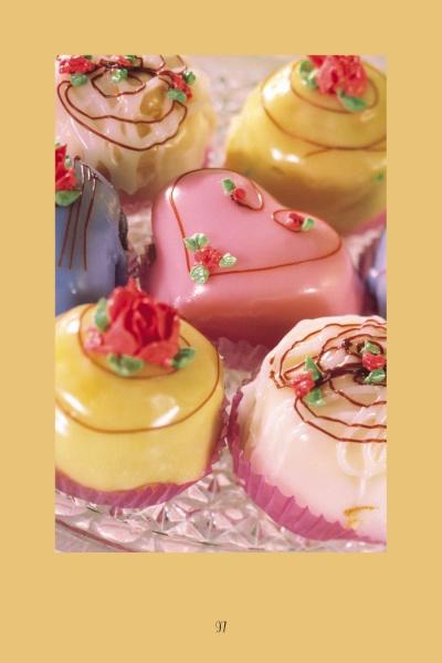 Enjoy an array of colorful, heart-shaped and round petit fours with icing roses and swirls, beautifully displayed— the perfect treats to accompany your next session with The Tarot Playbook.