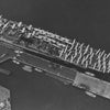A black and white aerial photo from Schiffer Publishing, Ltd. features the USS Yorktown (CV-5), a renowned WWII aircraft carrier docked at a pier with airplanes on deck, surrounded by docks, water, shoreline, parked cars, and landscaping.