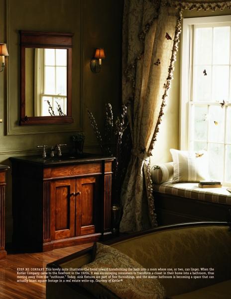 The Spa Bath by Schiffer Publishing, Ltd. showcases a warmly lit bathroom with a wooden vanity, mirror, wall sconce, vase with tall branches, and floral-curtained window seat—perfect for relaxing in spa-style comfort as sunlight streams in.