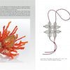 A spread from "Artistry in Fiber, Vol. 3" by Schiffer Publishing, Ltd. shows Riajo Huisman's gold wirework ring with orange coral-like details and two silver floral pendants on red cords, plus her portrait at top left.
