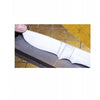 A knifemaker holds a partially finished integral knife blank on a sharpening stone, shown over a yellow work surface in "Making Integral Knives" by Schiffer Publishing, Ltd., a book/manual about knife making.