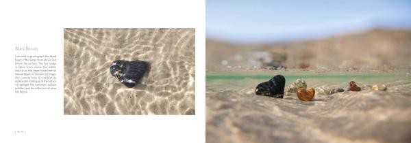 The "My Heart Rocks" photo book by Schiffer Publishing, Ltd. captures a heart-shaped black rock and colorful stones nestled in clear water, sunlight casting gentle ripples and reflections on the sandy bottom.