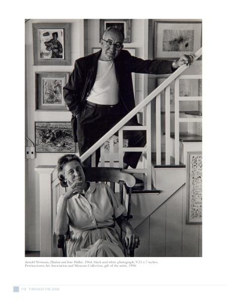 A black-and-white photo of a man in glasses on a staircase above a seated woman, surrounded by art, embodies the creative spirit celebrated in "Perspectives on the Provincetown Art Colony" by Schiffer Publishing, Ltd.