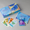 Inspiring Butterflies by Schiffer Publishing, Ltd. is a boxed set featuring a blue butterfly design, a guidebook, a self-discovery workbook, and colorful butterfly cards, all displayed on a light gray surface.