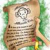 A hand holds a "Monkey of the Month" scroll by Schiffer Publishing, Ltd., featuring a cartoon monkey and yellow seal—an ideal birthday gift—against a textured green background.