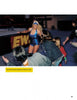 A woman in a shiny blue wrestling outfit enters an arena, smiling at fans. Caption: From "Hard Boys and Bad Girls" by Schiffer Publishing, Ltd., 2004.