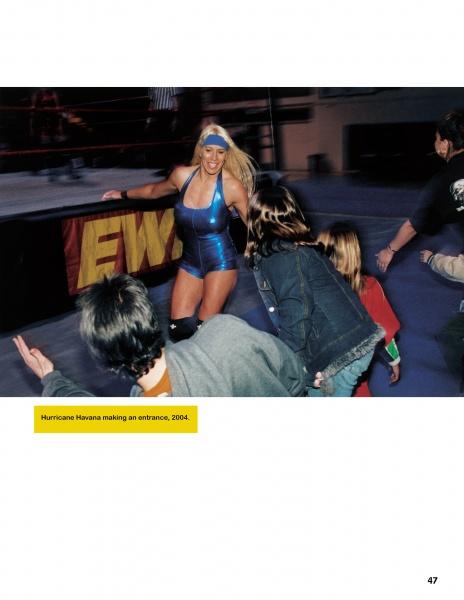 A woman in a shiny blue wrestling outfit enters an arena, smiling at fans. Caption: From "Hard Boys and Bad Girls" by Schiffer Publishing, Ltd., 2004.