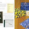 An open "Print It!" craft book by Schiffer Publishing, Ltd. shows instructions and materials for lino-wrapped paper with a floral print on the left and four blue, white, and gold patterned gifts on a wooden floor on the right.