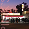 A crowd waits at dusk outside Pink’s, a renowned chili dog and burger stand, featured in Southern California Eats 2 by Schiffer Publishing, Ltd.—an iconic example of the vintage diners that define Los Angeles’s historic food scene.