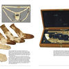 A spread from "Artifacts of the Battle of Little Big Horn" by Schiffer Publishing, Ltd. shows old socks and an undergarment thought to be Custer artifacts on the left, and a wooden case with antique pistols on the right.