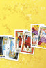 Five vibrant Tarot in Reverse cards from Schiffer Publishing, Ltd. are arranged diagonally on a yellow floral background, showing both upright and reversed cards: The High Priestess, The Emperor, The Hierophant, and The Lovers.