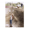 Workers spray concrete into a DIY skatepark bowl as others smooth the surface, capturing scenes featured in "FDR Skatepark: A Visual History" by Schiffer Publishing, Ltd., beneath an overcast sky.