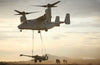 A Tilt Rotor Aircraft by Schiffer Publishing, Ltd. lifts a tank with cables as soldiers stand nearby at sunset.