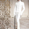 Dressed in white formalwear—top hat, gloves, boots—and accessorized with round sunglasses and a black cane, a model stands by a gold-patterned screen, showcasing International Steampunk Fashions from Schiffer Publishing, Ltd.
