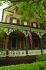 Featured on Cape May Walking Tours by Schiffer Publishing, Ltd., a house with a flag on the porch highlights the town's charming architecture and rich history.
