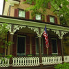 Featured on Cape May Walking Tours by Schiffer Publishing, Ltd., a house with a flag on the porch highlights the town's charming architecture and rich history.