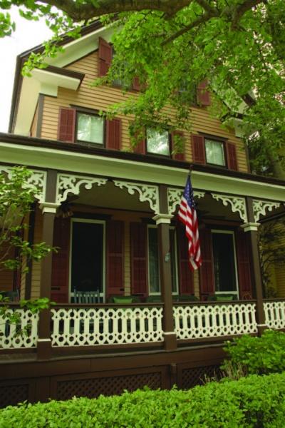 Featured on Cape May Walking Tours by Schiffer Publishing, Ltd., a house with a flag on the porch highlights the town's charming architecture and rich history.