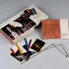 The Ghost Hunters' Tool Kit by Schiffer Publishing, Ltd. includes a box, instruction booklet, metal dowsing rods, and colorful image-and-text cards—all neatly displayed on a gray surface for ghost investigations.