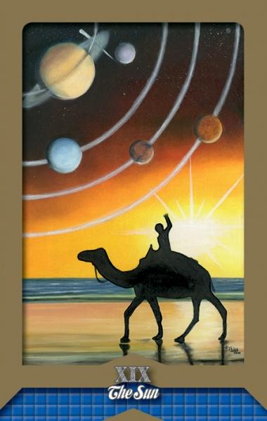 A person riding a camel along a beach at sunset raises an arm as planets and orbital lines glow above. The bright sun gleams on the horizon in this striking card, XIX The Sun, from the Tarot of the Moors by Schiffer Publishing, Ltd.