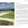 A pathway lined with American flags runs beside a river and blooming garden under a partly cloudy sky, captured in "North Shore Wide" by Schiffer Publishing, Ltd.—a classic photograph evoking patriotism and tranquility in Massachusetts.