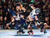 Three modern roller derby players in helmets and pads clash and fall on a rink during intense action in "No Mercy" by Schiffer Publishing, Ltd., as a crowd watches this thrilling contact sport.