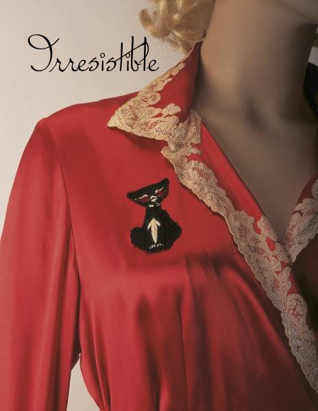 A mannequin displays vintage-inspired elegance in a red dress with a beige lace collar and black cat brooch. “Irresistible: The Art of Lingerie, 1920s-1980s” by Schiffer Publishing, Ltd. appears in cursive at the top left.