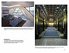 Power Rooms by Schiffer Publishing, Ltd. showcases modern corporate spaces with blue sofas, glass walls, city views, grand hallways with blue carpets, marble columns, and ornate ceilings adorned with chandeliers.