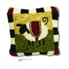 The "How to Hook Rugs" pillow by Schiffer Publishing, Ltd. showcases a white sheep with a black face and legs on a green and yellow background, accented with a black and white striped border and red corners.