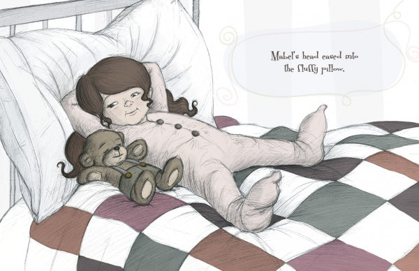 A young girl in one-piece pajamas lies on her bed next to a stuffed monkey, with a checkered quilt and pillow. Text from Schiffer Publishing’s "Mabel and the Queen of Dreams" reads: Mabel’s head eased into the fluffy pillow.