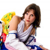 A cosplayer poses on the floor in a colorful outfit, modeling for "Undressing the Art of Playing Dress Up" by Schiffer Publishing, Ltd., against a white background and looking directly at the camera.