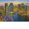 Miami At Night" by Schiffer Publishing, Ltd. captures tall, illuminated buildings reflecting on the water under a blue-orange sky, making it a striking addition to any cityscape photography book.