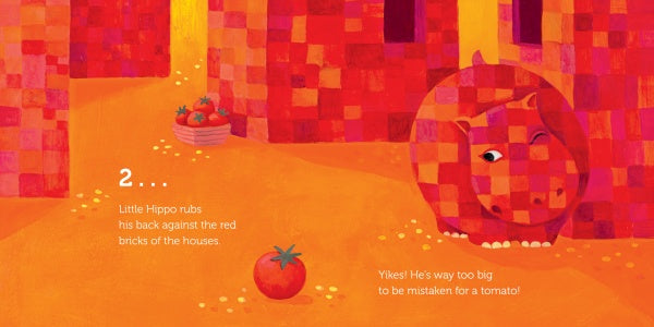 In "Hide-and-Seek with Little Hippo" by Schiffer Publishing, Ltd., a small orange-and-red hippo inspired by an Egyptian figurine playfully rubs against red brick houses near a basket of tomatoes, but he's much too big to be a tomato!.