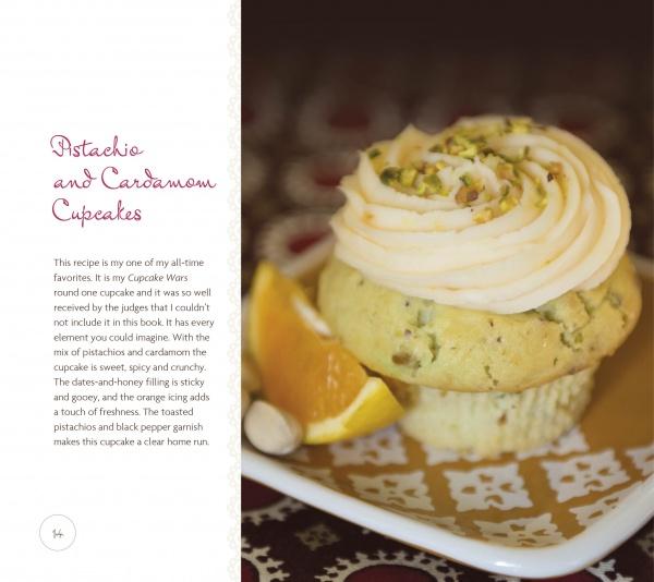 A pistachio and cardamom cupcake with swirled frosting and chopped pistachios sits on a plate beside a lemon wedge. The book "Dare to Bake!" by Schiffer Publishing, Ltd. is featured, highlighting creative cupcake recipes and flavors.