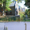 James River Reflections" by Schiffer Publishing, Ltd. captures a stone building by the calm James River, framed by trees and a wooden fence, with sunlight through the leaves, birds above the water, and text overlaying this tranquil Virginia scene.