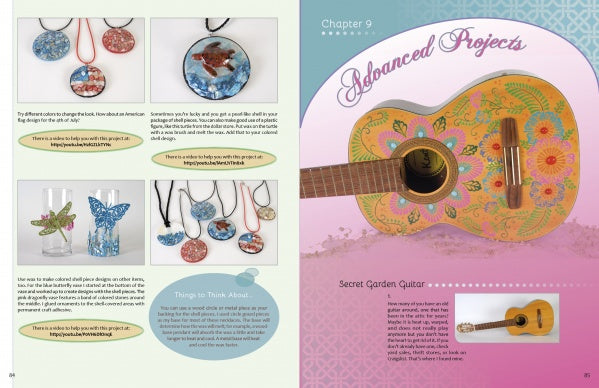An open craft book, Wax on Crafts by Schiffer Publishing, Ltd., shows crayon wax jewelry (pendants, brooches) on the left and a decorated guitar under "Advanced Projects: Secret Garden Guitar" on the right.