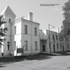 Black and white photo of the Old Clay County Jail—a two-story, white brick building with a tower and arched windows—featured in Schiffer Publishing, Ltd.'s "Women in White," known for its connections to northeast Florida ghost stories.